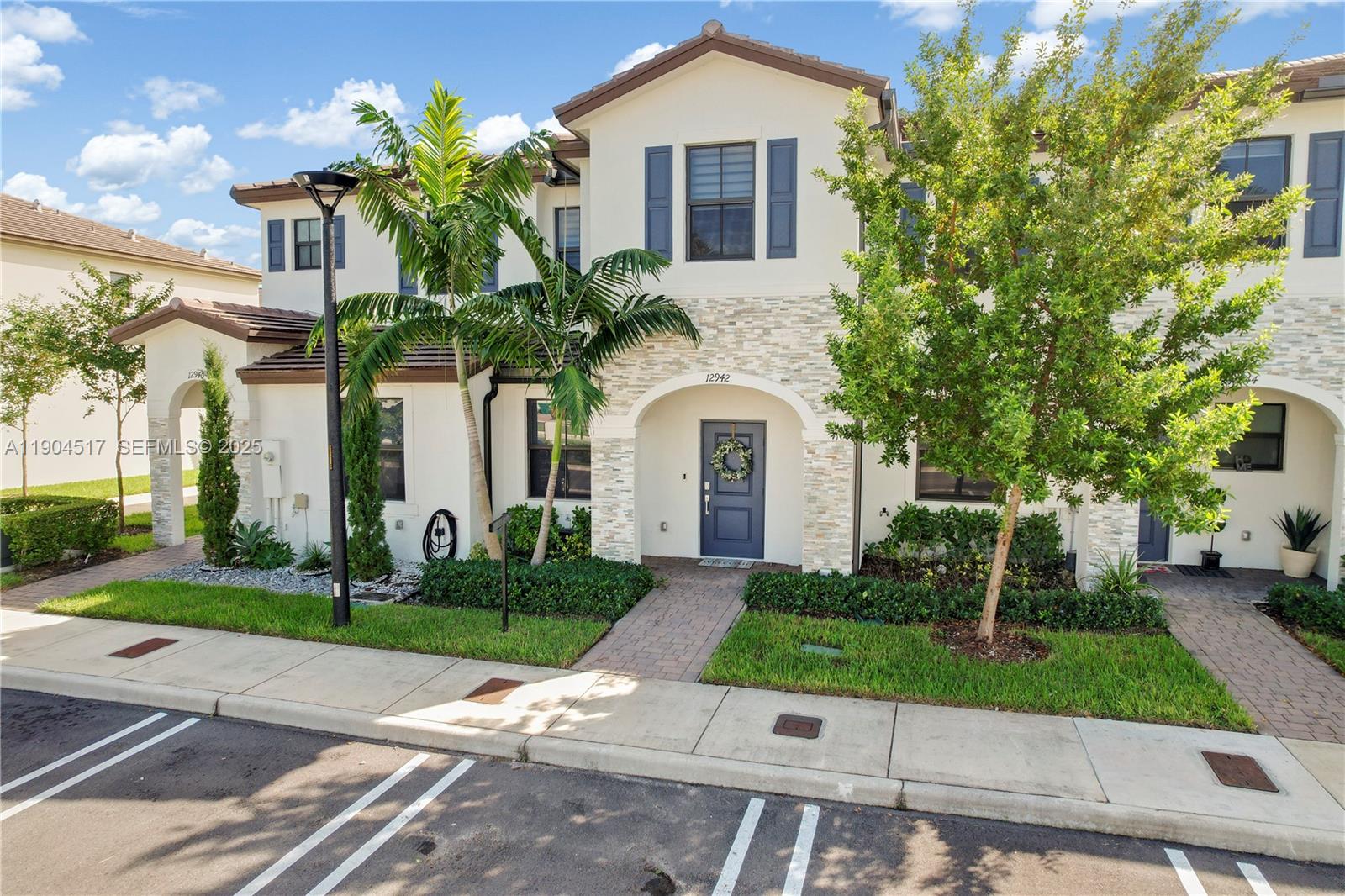a front view of a house with a yard and potted plants