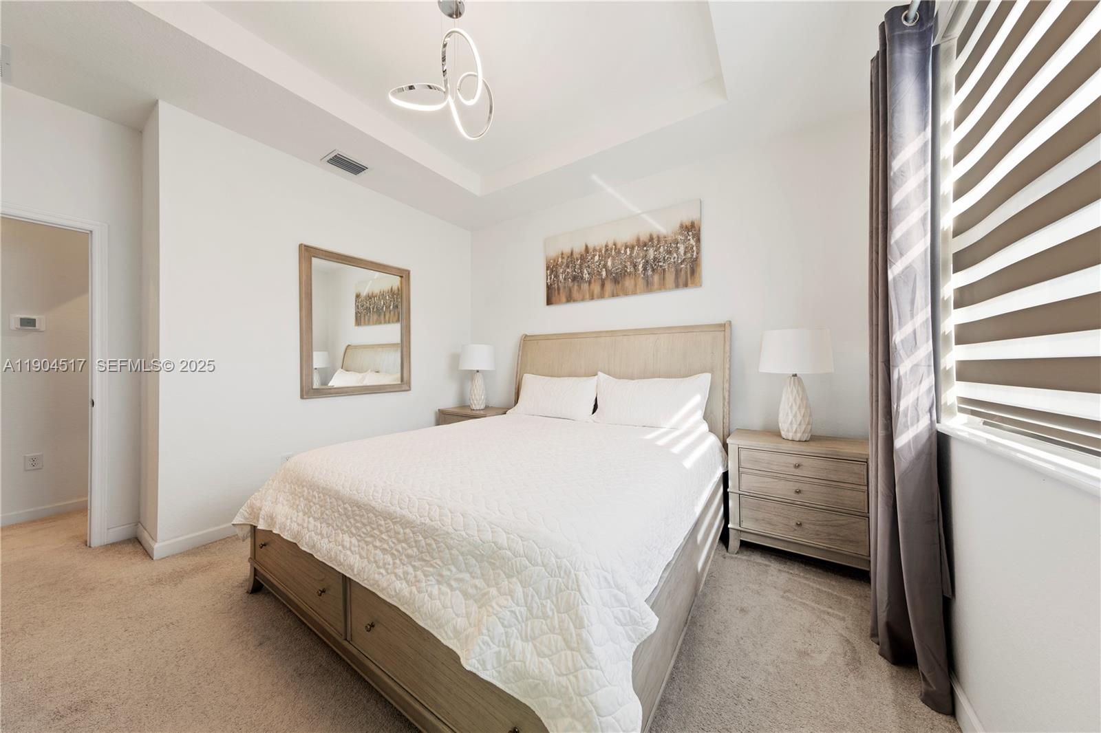 12942 Southwest 232nd Terrace Homestead, FL 33032 - Photo 12 of 27 a bedroom with a bed and a chandelier