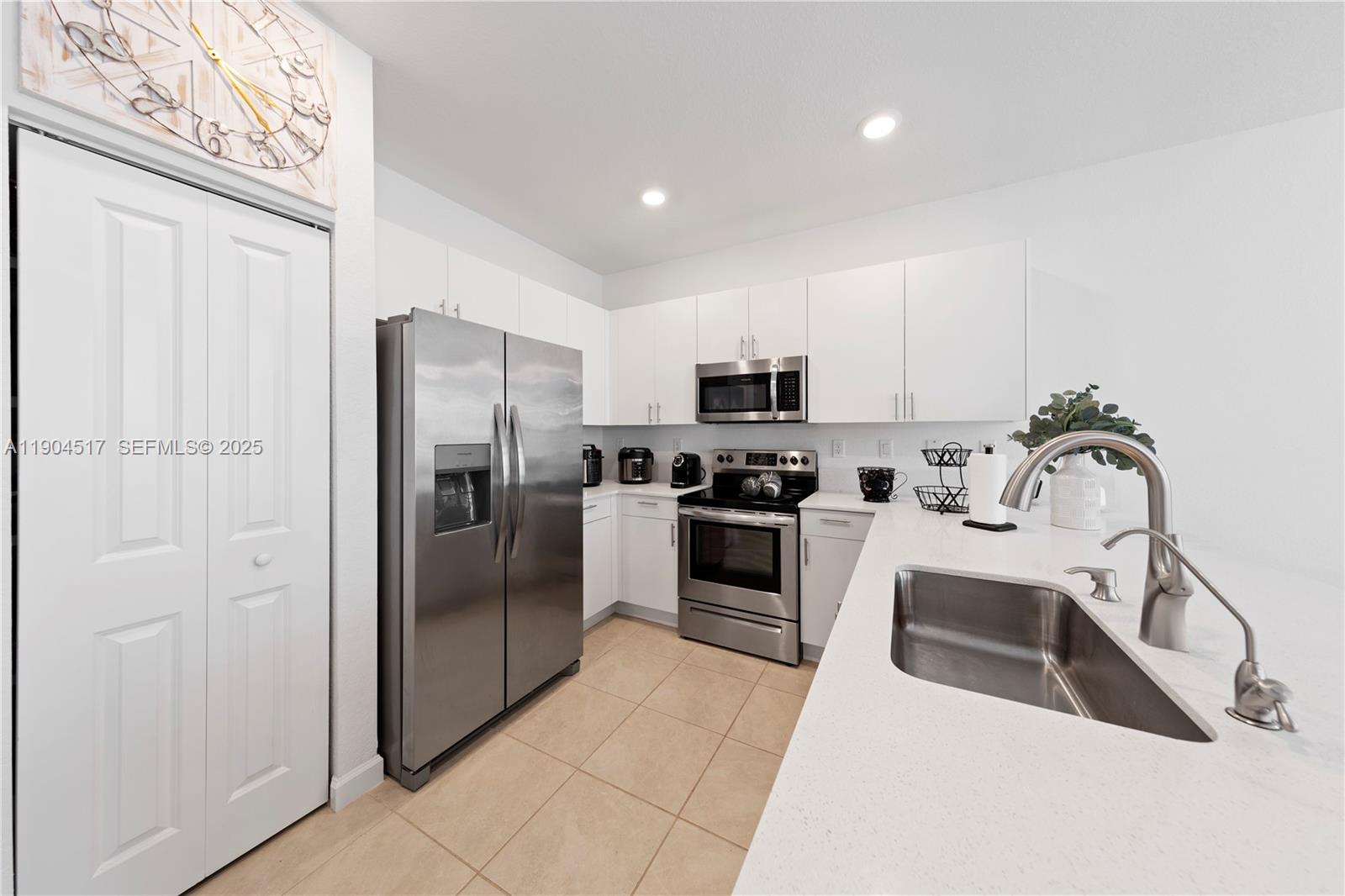 12942 Southwest 232nd Terrace Homestead, FL 33032 - Photo 4 of 27 a kitchen with white cabinets and stainless steel appliances