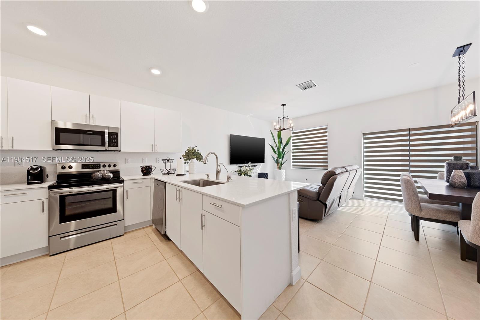 12942 Southwest 232nd Terrace Homestead, FL 33032 - Photo 8 of 27 a kitchen with stainless steel appliances a stove a sink a microwave and a refrigerator