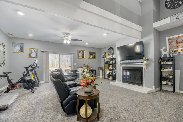a living room with furniture a flat screen tv and a fireplace