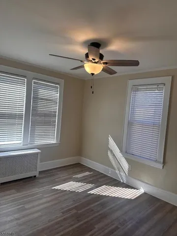 a view of wooden floor and a chandelier fan in a room