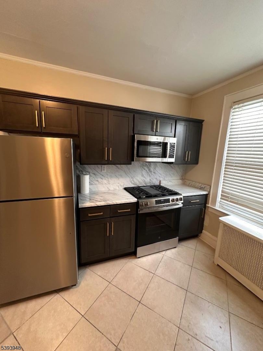 25 Union Place, Unit 1L Irvington, NJ 07111 - Photo 8 of 12 a kitchen with a refrigerator sink and cabinets