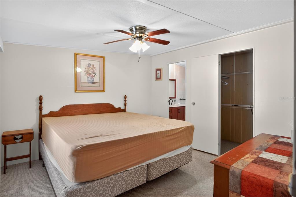 17536 Brinkerhoff Lane Okeechobee, FL 34974 - Photo 11 of 17 a bedroom with a bed and a chandelier