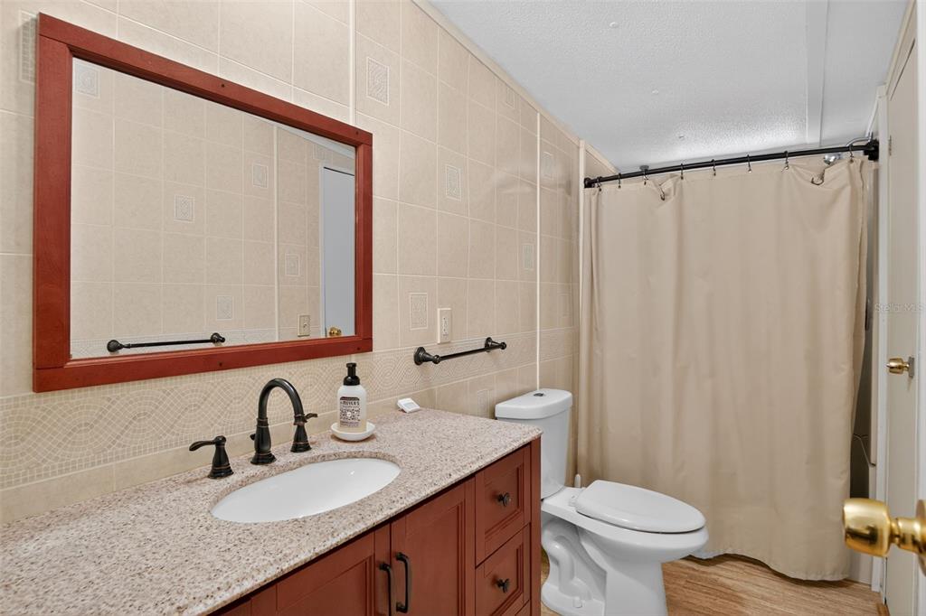 17536 Brinkerhoff Lane Okeechobee, FL 34974 - Photo 13 of 17 a bathroom with a granite countertop sink toilet and mirror
