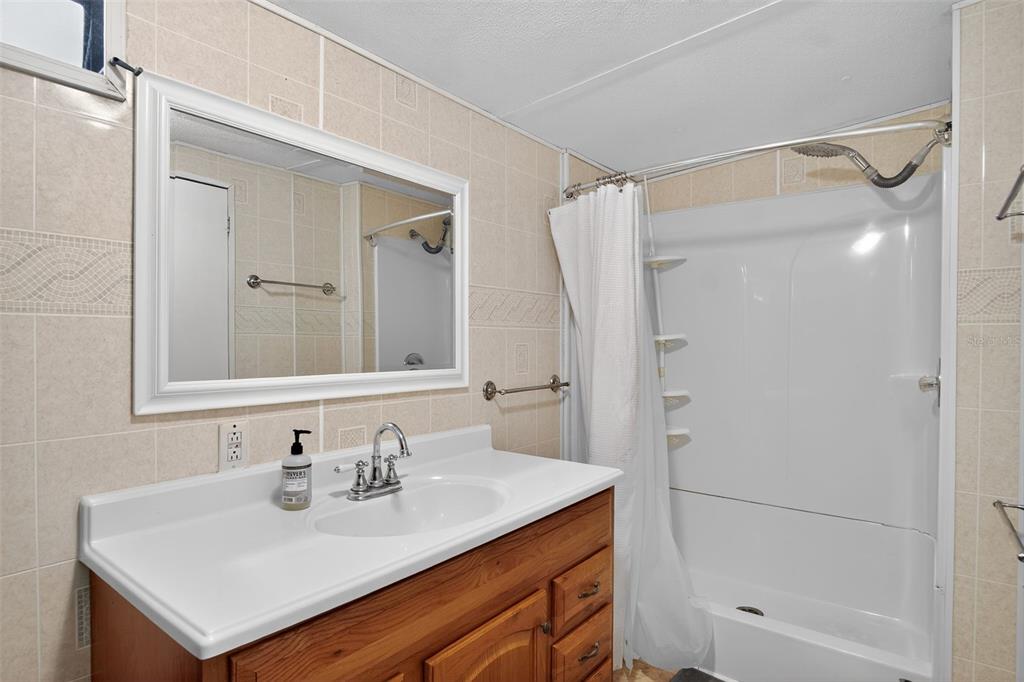 17536 Brinkerhoff Lane Okeechobee, FL 34974 - Photo 14 of 17 a bathroom with a sink vanity mirror and shower
