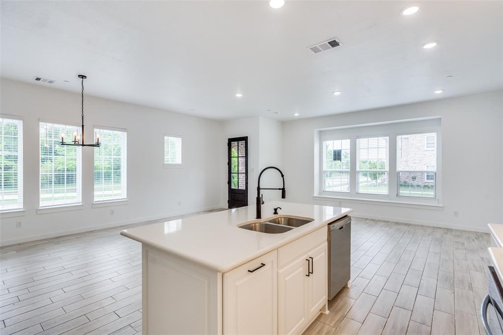 7207 Switchgrass Road Frisco, TX 75033 - Photo 15 of 26 a kitchen with a sink and wooden floor