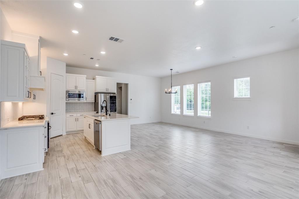 7207 Switchgrass Road Frisco, TX 75033 - Photo 16 of 26 a view of kitchen with wooden floor and electronic appliances