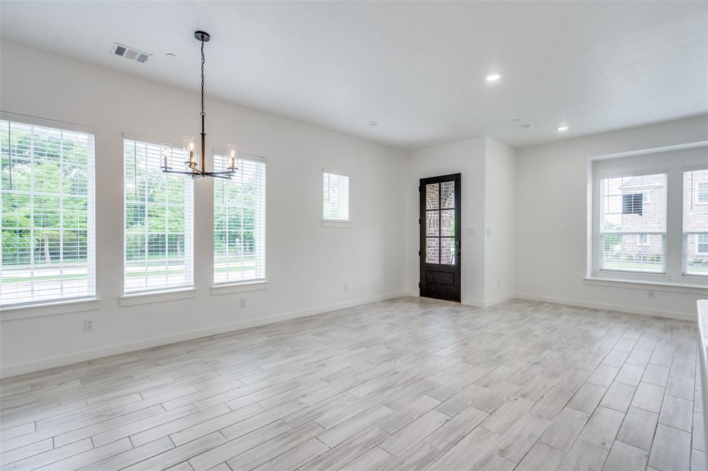 7207 Switchgrass Road Frisco, TX 75033 - Photo 4 of 26 a view of an empty room with a window and wooden floor