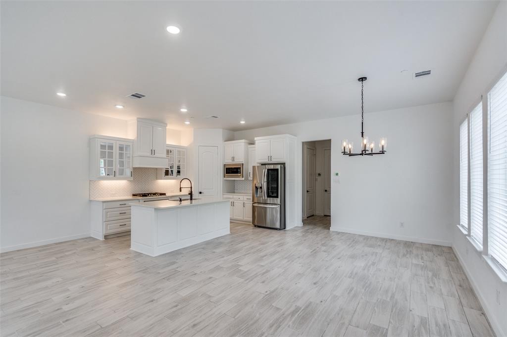 7207 Switchgrass Road Frisco, TX 75033 - Photo 5 of 26 a view of a kitchen with stainless steel appliances refrigerator stove microwave and cabinets