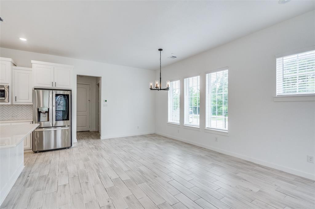 7207 Switchgrass Road Frisco, TX 75033 - Photo 8 of 26 an empty room with wooden floor and windows