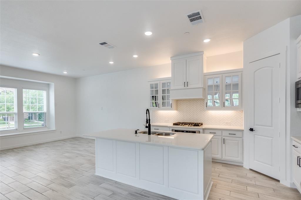 7207 Switchgrass Road Frisco, TX 75033 - Photo 10 of 26 a kitchen with kitchen island stainless steel appliances a sink and a window