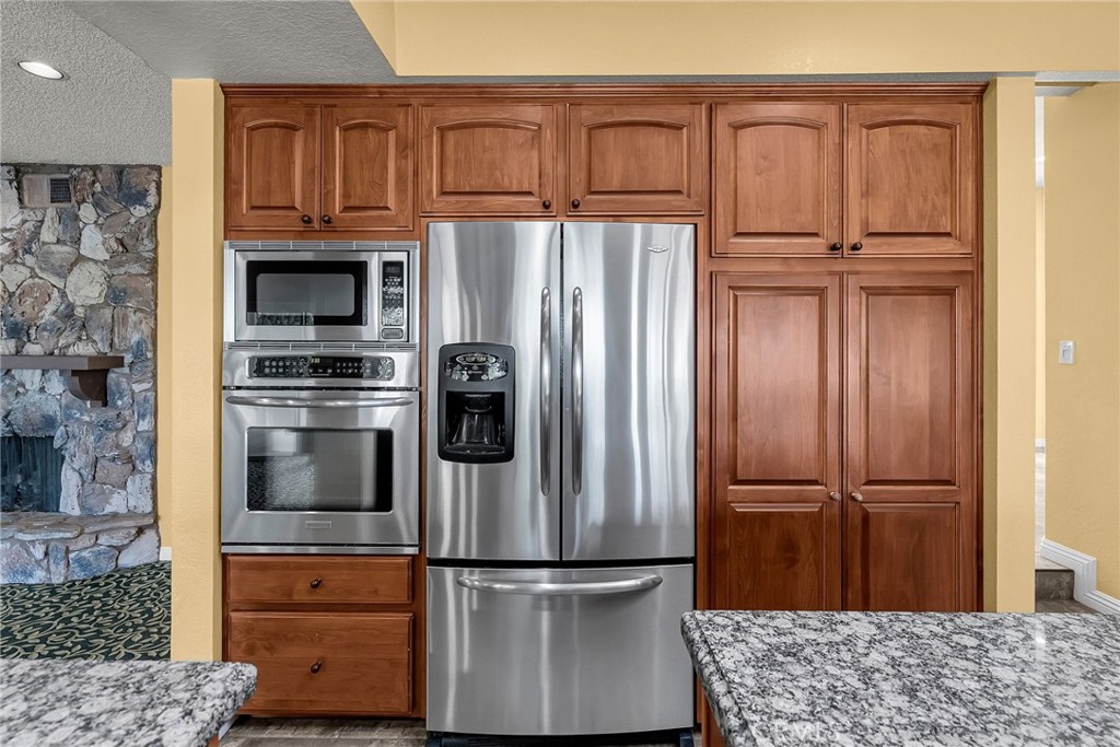 1249 Coronet Drive Riverside, CA 92506 - Photo 12 of 57 a kitchen with stainless steel appliances granite countertop a refrigerator and a sink