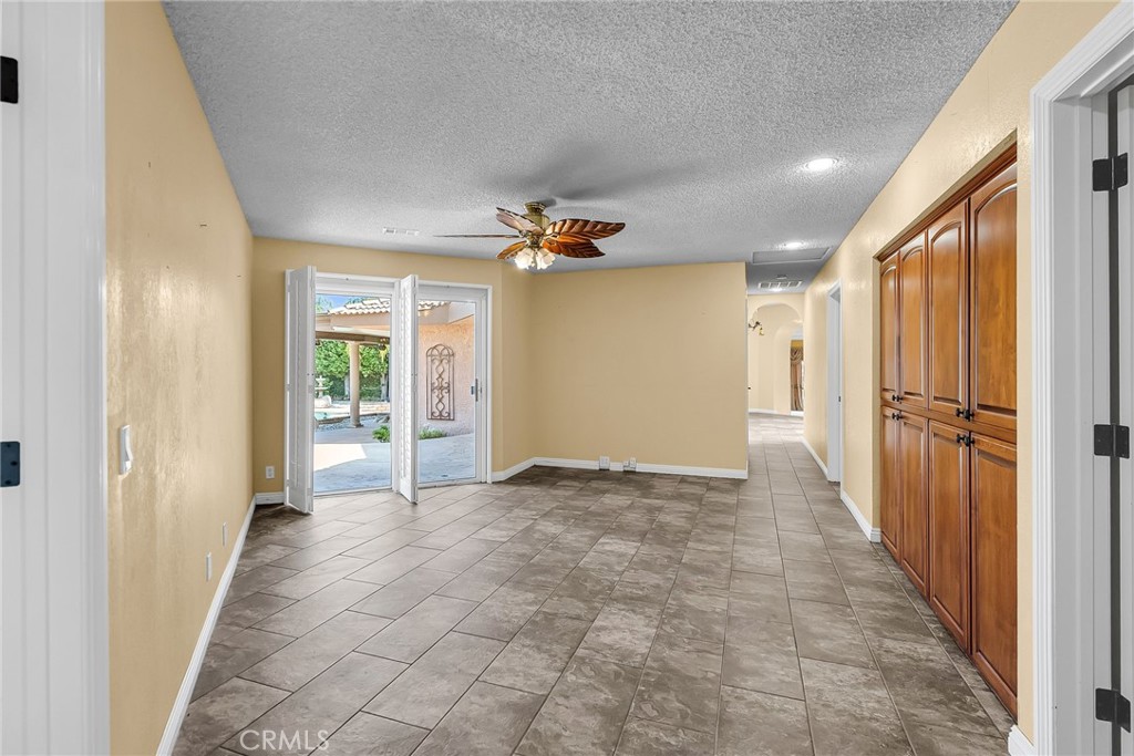 1249 Coronet Drive Riverside, CA 92506 - Photo 27 of 57 a view of a hallway with a glass door and furniture