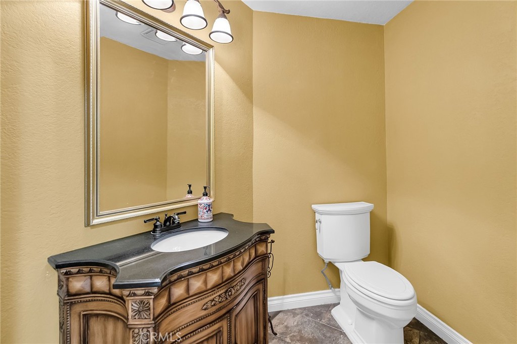 1249 Coronet Drive Riverside, CA 92506 - Photo 33 of 57 a bathroom with a sink a toilet and mirror