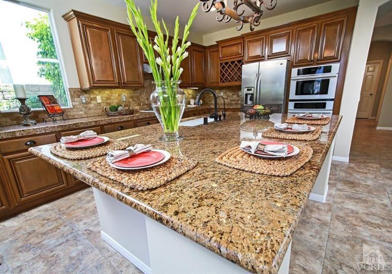14303 Peach Hill Road Moorpark, CA 93021 - Photo 16 of 41 a kitchen with stainless steel appliances granite countertop a sink a stove and a wooden floor