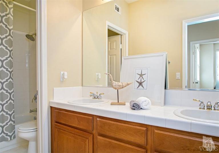 14303 Peach Hill Road Moorpark, CA 93021 - Photo 31 of 41 a bathroom with a sink and a mirror with toilet