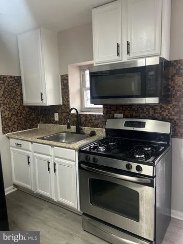 a kitchen with granite countertop a stove and a microwave
