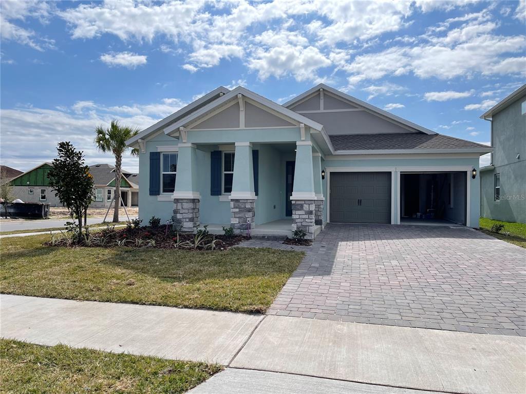 19284 Allium Place Orlando, FL 32827 - Photo 1 of 15 a front view of a house with a yard garage and outdoor seating