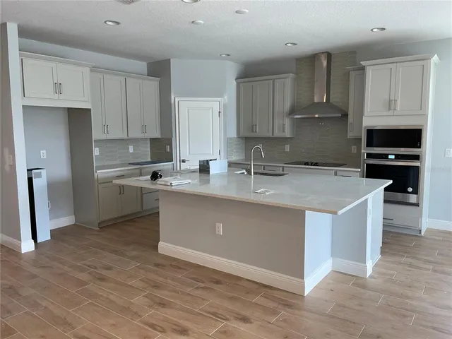 a kitchen with stainless steel appliances granite countertop a sink a stove a refrigerator and cabinets