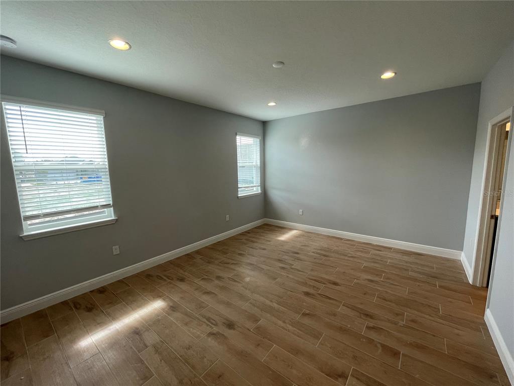 19284 Allium Place Orlando, FL 32827 - Photo 9 of 15 an empty room with wooden floor and windows