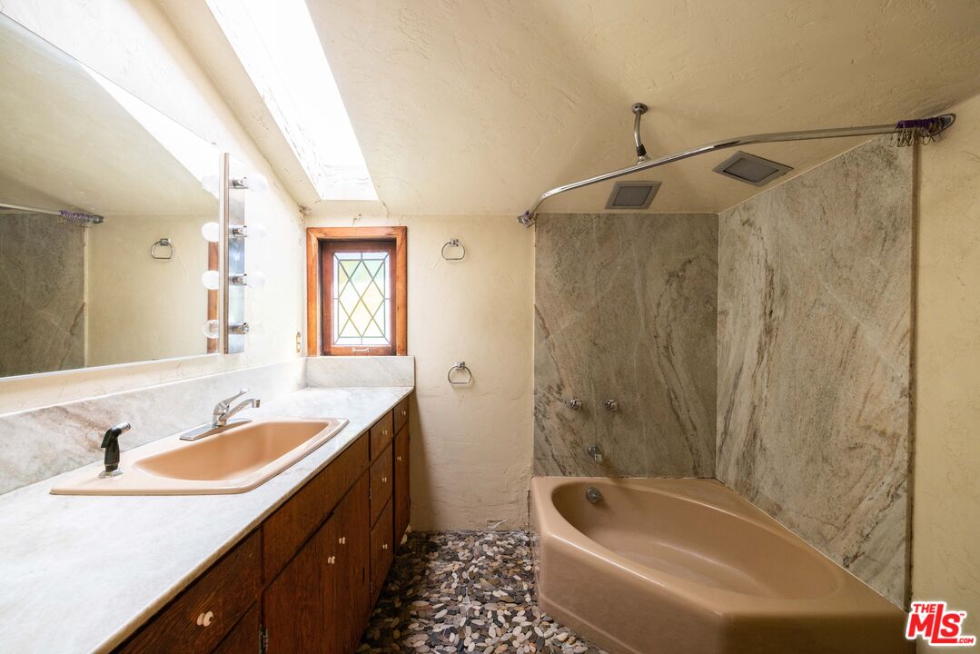 1748 Laurel Canyon Boulevard Los Angeles, CA 90046 - Photo 18 of 24 a bathroom with a tub sink and mirror
