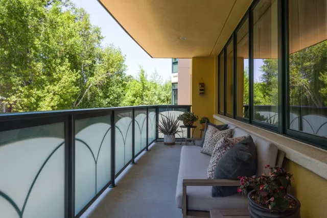 a balcony with wooden floor stairs and furniture