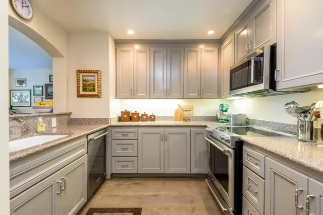 a kitchen with a sink stove top oven and cabinets