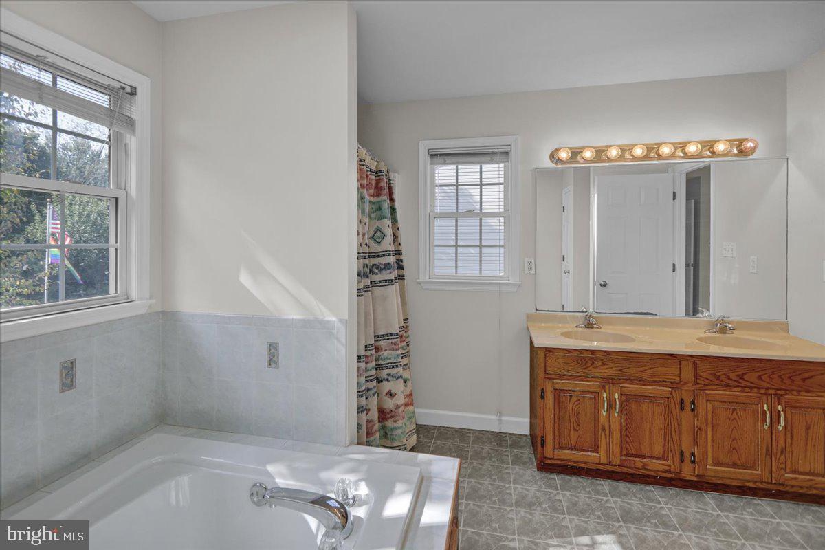 10 Virginia Avenue Sinking Spring, PA 19608 - Photo 23 of 35 a bathroom with a granite countertop sink and a bathtub
