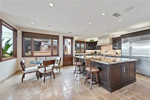 a kitchen with stainless steel appliances granite countertop a table and chairs