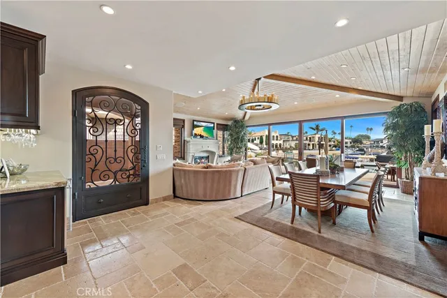 a room with lots of tables a chandelier a large window and potted plants