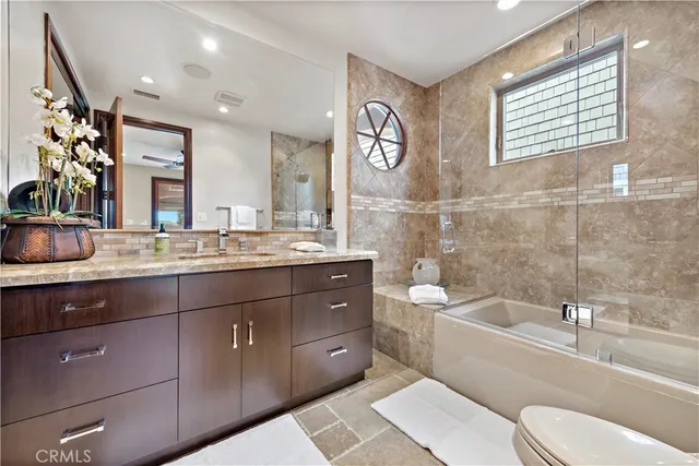 a bathroom with a granite countertop sink mirror toilet and bathtub