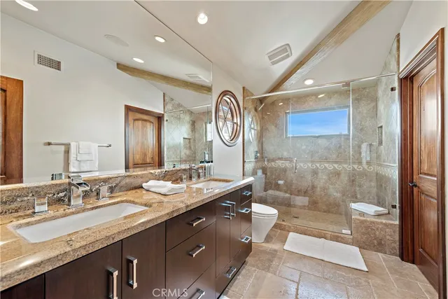 a bath room with a sink double vanity and a mirror