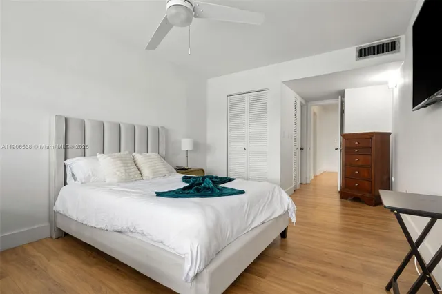 a bedroom with a bed and a flat tv screen on a dresser