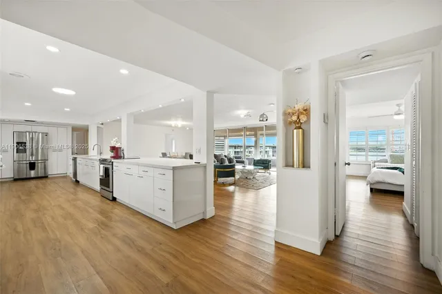 a view of a living room kitchen with furniture and a wooden floor