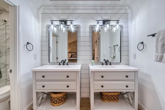 a bathroom with a double vanity sink mirror and shower