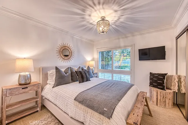 a bedroom with a bed and a chandelier