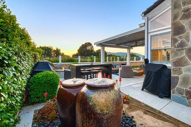 a view of a patio with lawn chairs under an umbrella