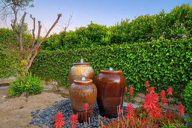 a wooden bench sitting in backside of a house with potted plants