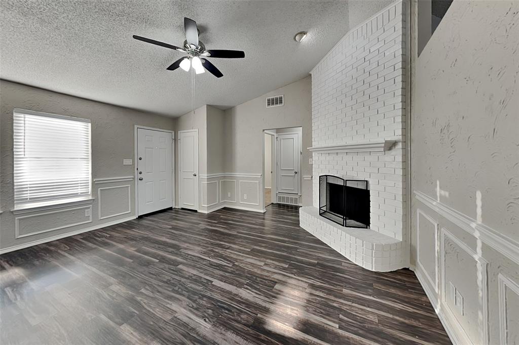 7836 Prairie Drive Watauga, TX 76148 - Photo 2 of 20 a view of a livingroom with a fireplace a ceiling fan and windows