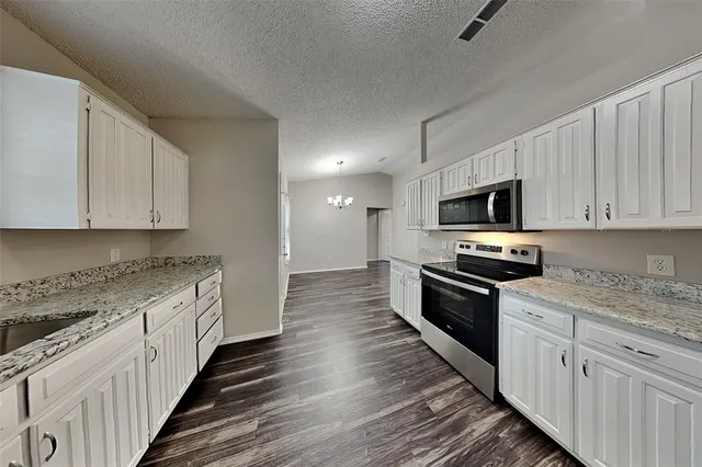 a kitchen with granite countertop a sink and steel appliances
