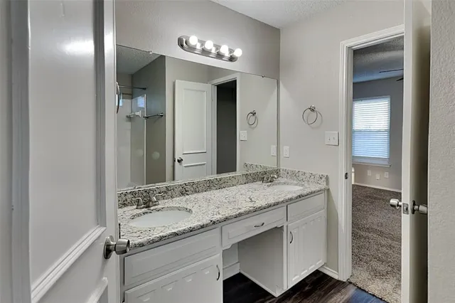 a bathroom with a granite countertop sink and a mirror