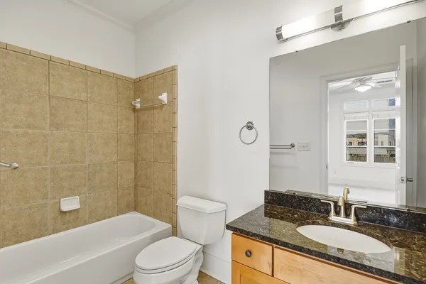 a bathroom with a granite countertop sink toilet tub and shower