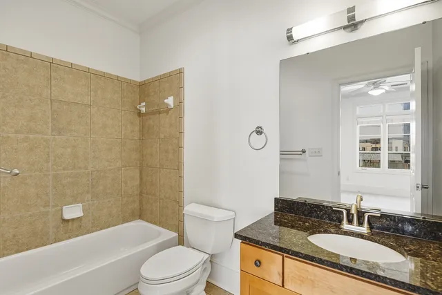 a bathroom with a granite countertop sink toilet tub and shower