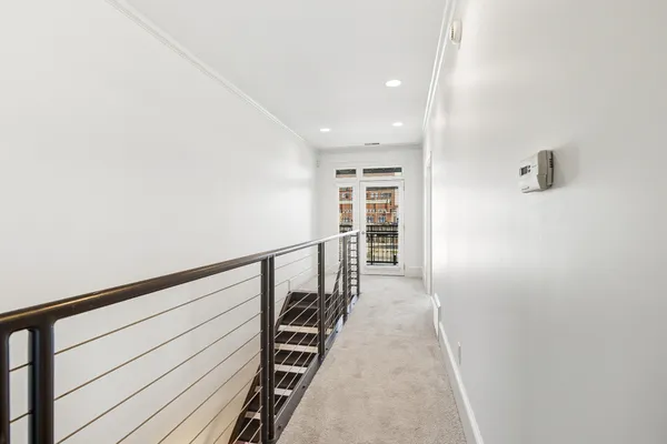 a view of a hallway with wooden floor and staircase