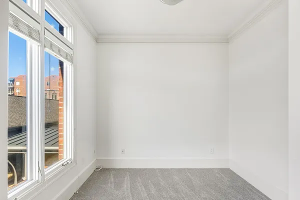 a view of a small space with wooden floor and a window