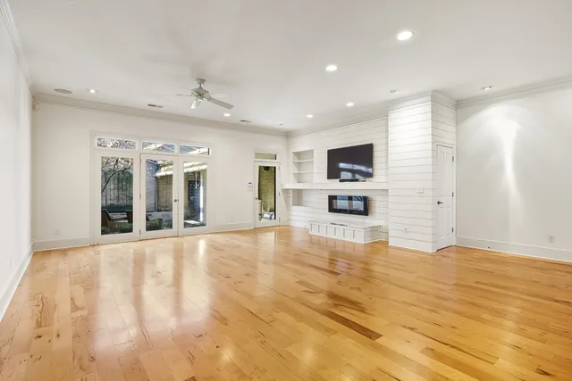 a view of an empty room with a kitchen and a window