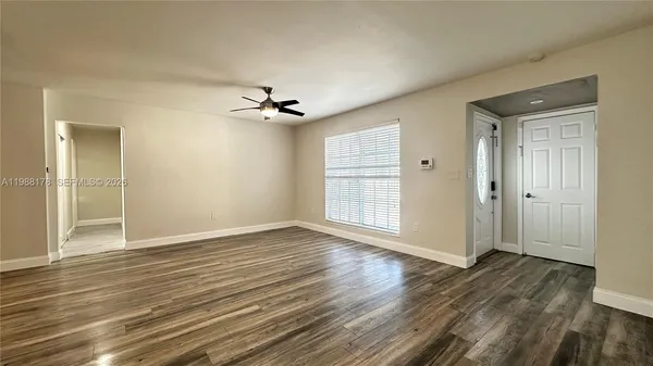 a view of an empty room with wooden floor