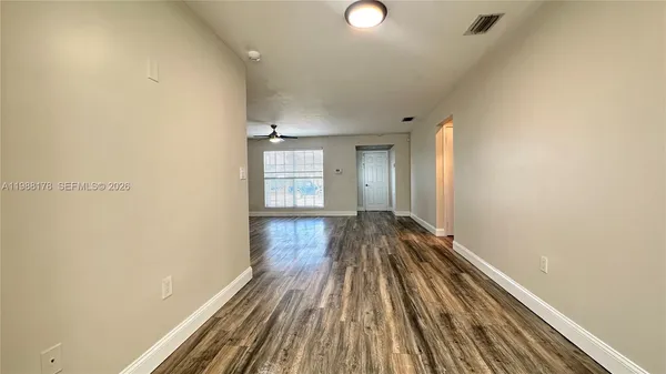 a view of a room with wooden floor and window