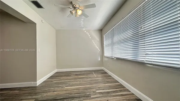 a view of a room with wooden floor and a window